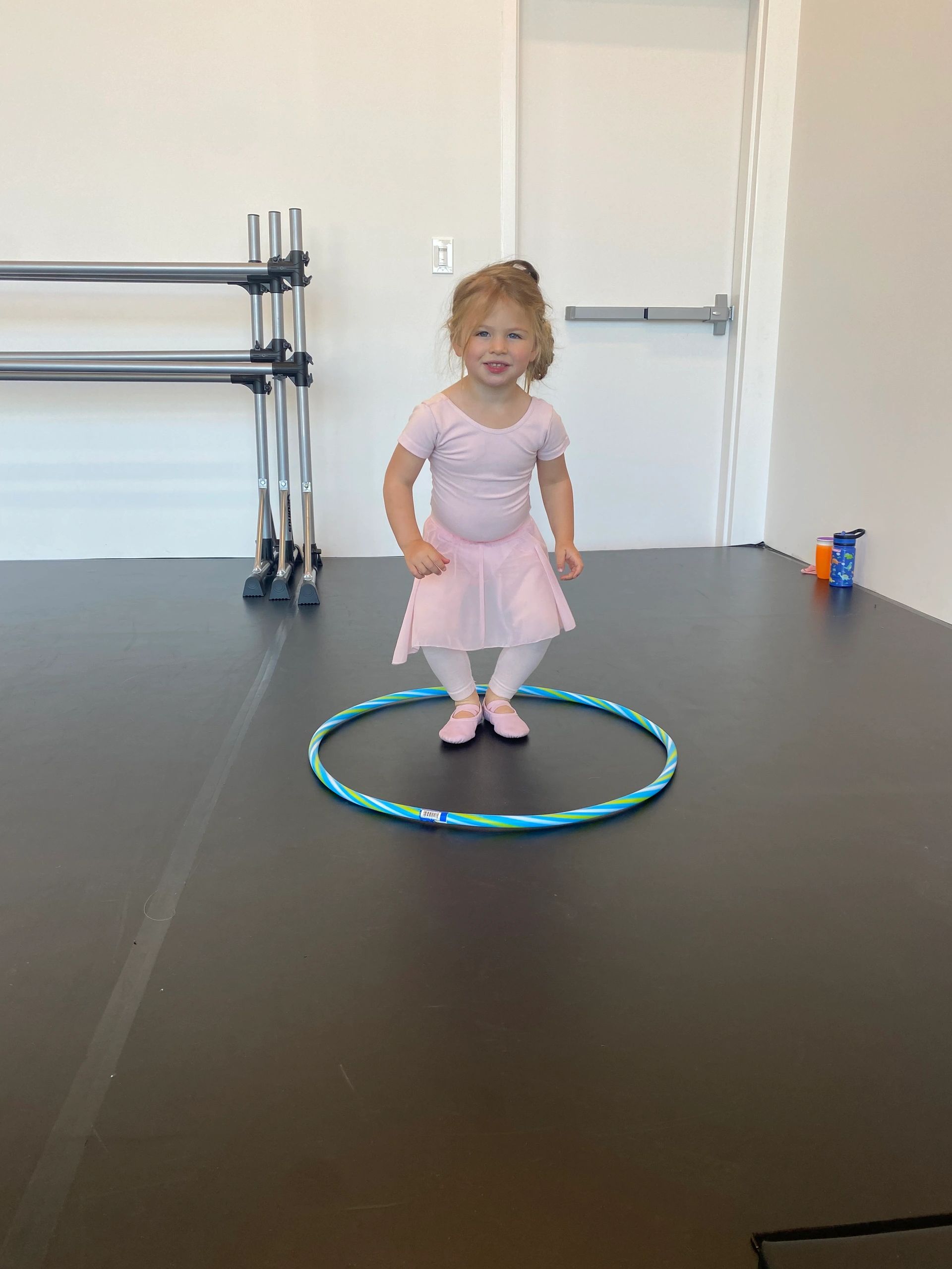 A young dancer holding a 'My First Day of Dance' sign at Dance Athletics Studio.
