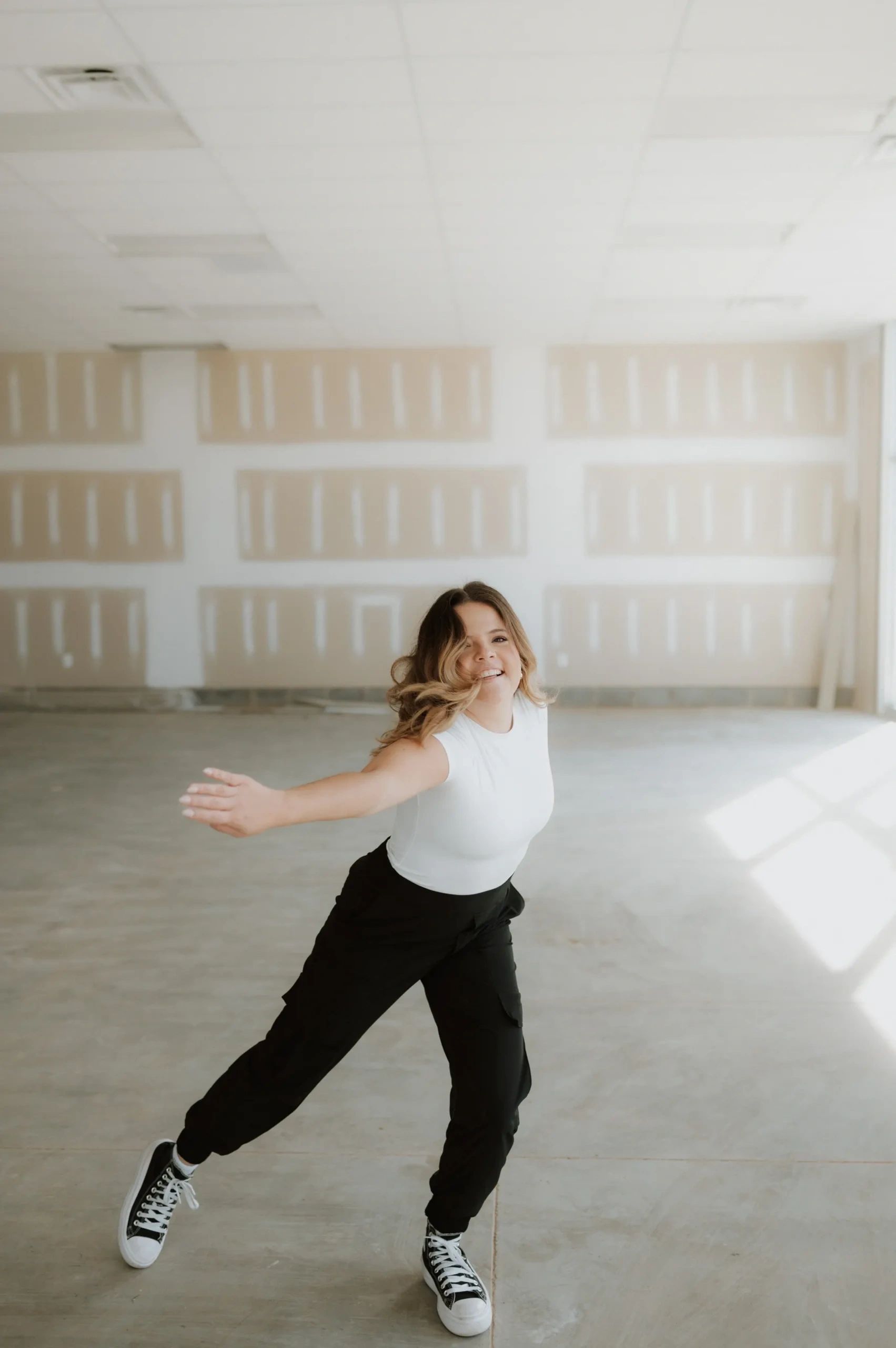 Black-and-white photograph of four young students standing at the ballet barre.