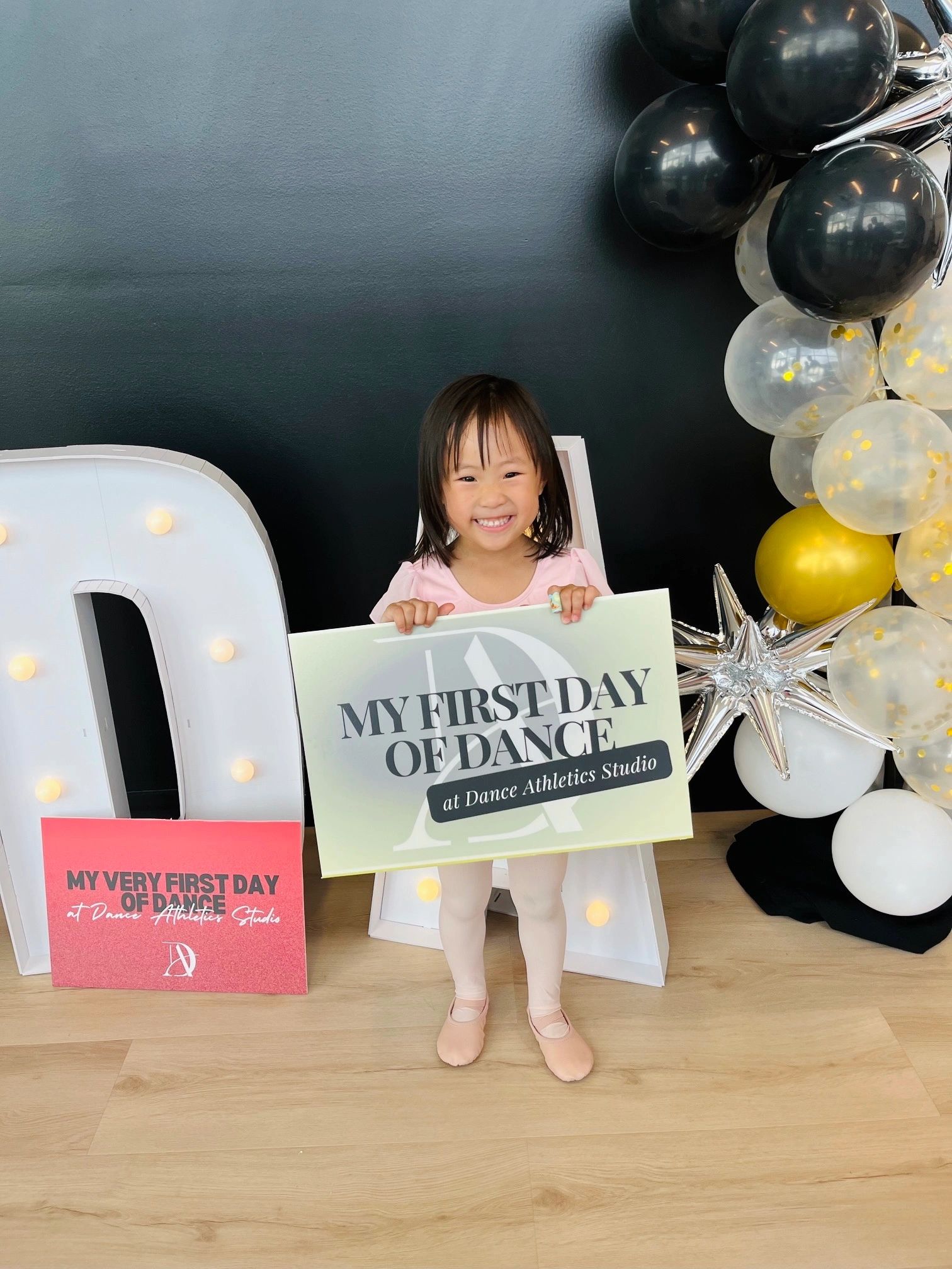 Five young students in pastel leotards at the ballet barre during a Fundamentals class.